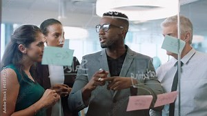 diverse business people using sticky notes african american team leader man brainstorming with colleagues working on solution discussing strategy writing on glass whiteboard in office meeting 4k