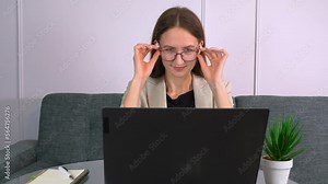 Happy young woman freelancer work on computer typing text messages from home, . she finishes work, leans back on couch and throws her hands behind her head. Job done. end of day