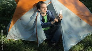 The man opens the tent, making a few photos on the phone and close the tent