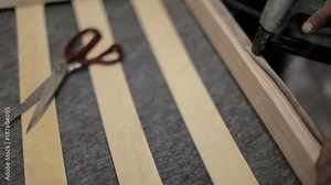 craftsman is working to build the sofa. manufacture of upholstered furniture.