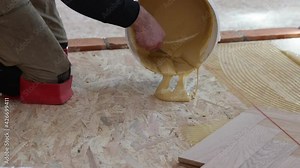 Laying parquet in an apartment during renovation. Herringbone parquet video 4k. Worker installing wood parquet.