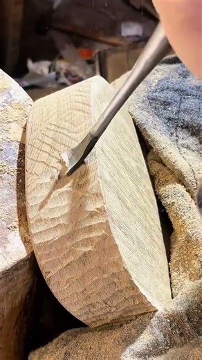 carving a wooden bowl with a metal chisel creating unique textures and patterns on its surface now