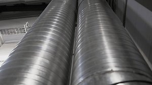 Steel wastewater distribution pipes in treatment plant workshop. Chemical processing system installed in factory shop. Industrial facility