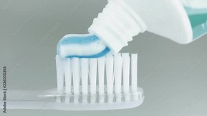 Toothbrush and toothpaste. Close up shot of toothpaste being put on toothbrush.