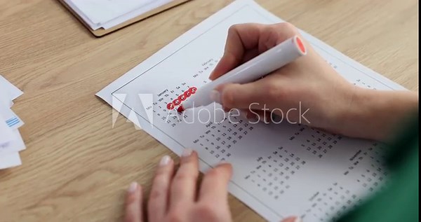 Woman marks dates on a calendar concept