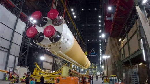 Massive Core Stage for NASA Artemis II Moon Rocket Moved | Kennedy Space Center FriendsofNASA.org: Technicians use massive cranes inside the Vehicle Assembly Building (VAB) at NASA Kennedy’s Space Center in Florida to lift the fully assembled Space Launch System (SLS) core stage vertically 225-feet above the ground from High Bay 2 to a horizontal position in the facility’s transfer aisle. In the transfer aisle, technicians conducted final preparations of the core stage before it was integrated w