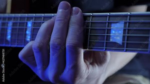 Male hand playing on guitar strings, learning new chords. Guitarist performing guitar solo