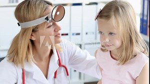 Female doctor in uniform examines girl ear with professional device octoscope. Work process of specialist at examination of child in light clinic slow motion