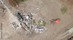 Waste sorting - Aerial footage of workers manually sorting types of waste at a local recycling facility.