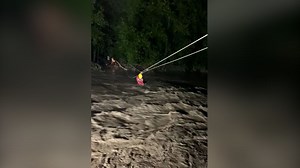 Dramatic video shows rescuers using zip line to carry civilians across raging floodwaters