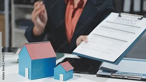 Female Real Estate Broker presenting and advised to model home and building project detail in the office, sign purchase sales contract, agreements concerned mortgage loan offer and insurance.