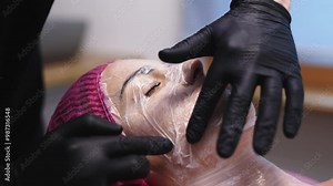 A specialist applies anesthesia to a young woman's face and places a cosmetic mask before injections. This step ensures comfort and helps achieve optimal results during the procedure.