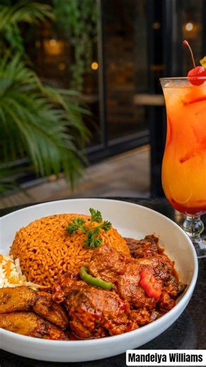 A delicious plate of spicy jollof rice served with tender chicken, fried plantains.