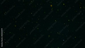 Like small specs of light on dark sky, coloured particles, slow motion