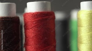 Sewing Threads On Spool. Extreme Closeup. Colorful spools of thread in textile factory. A Lot of Colors of thread. Camera boom or jar down.