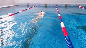 Woman swimming in a swimming pool. Slow motion.