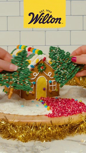 Dare to sleigh and upgrade your gingerbread property this year, no house hunting required! 🏡✨ Flex your gingerbread decorating skills by thinking outside the box - literally: Add extra sprinkles, fluffy snow, a Peppermint Crunch Sprinkle Path, and Candy Melts on roofs and trees. | Wilton Cake Decorating