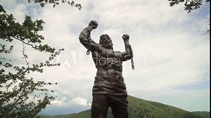 A huge sculpture of Prometheus on a rock filmed in motion on a stabilizer