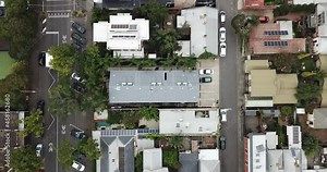 Static aerial perspective of white courier van driving along parallel city streets.