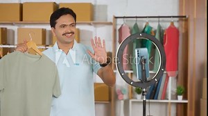 Indian influencer doing live streaming using mobile phone and ring light for social media marketing - concept of live commerce, ecommerce seller and vlogger