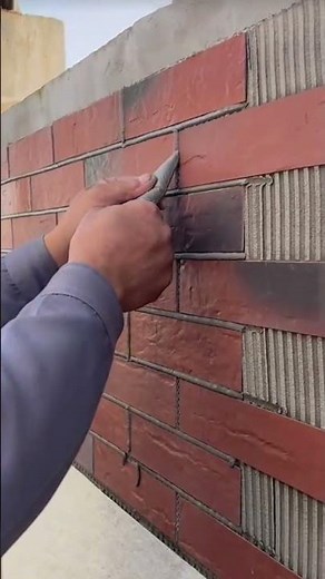 the process of filling black cream between the brick slabs of the house fence wall #construction