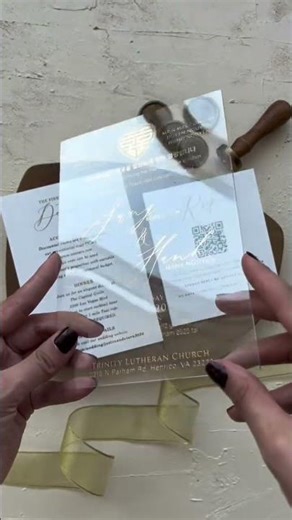 This acrylic wedding invitation features a smoky transparent finish paired with refined gold foil