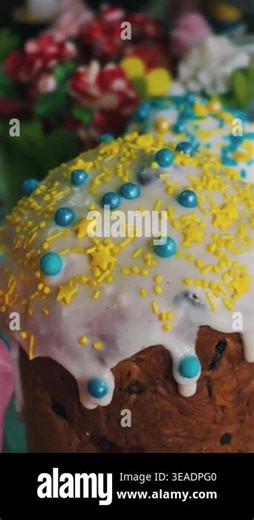 Traditional Easter kulich stands close-up with dripping white icing. The cake is decorated with yellow star-shaped sprinkles and blue edible beads. Blurred decorations are in the back Stock Video Footage - Alamy