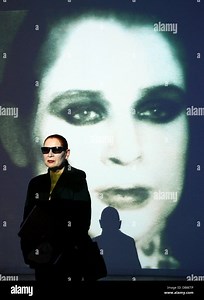 Photo and video artist Katharina Sieverding poses in front of a video image of herself during the press conference about her exhibition at Museum Schloss Moyland in Bedburg-Hau, Germany, 25 July 2013. The exhibition runs from 28 July until 24 November 2013. Photo: HORST OSSINGER Stock Photo - Alamy