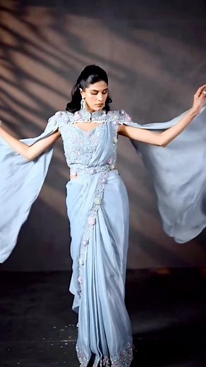 1K views | Where icy blue meets ethereal glam ❄️ Scalloped satin silk, a flowing cape and a delicate embroidered belt. This saree is crafted for evenings that deserve a little extra magic. Search Code: SBHA3900 ️ celebration, family, tradition, desi fashion, indianwear, wedding wear, indian wedding #eveningwear #cape #utsavfashion #blouse #saree | Utsav Fashion | Facebook