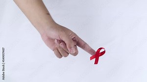 hand symbol with red ribbon signifying concern for people with HIV aids isolated on white background