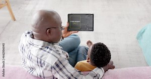 African american grandfather, grandson and tablet, shopping online on cyber monday, slow motion