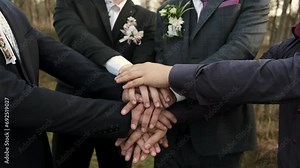 A group of men putting their hands together. A demonstration of unity, teamwork and friendship. Close-up aerial view of men coming together as a team.