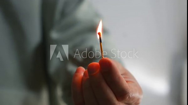 Lighting a match on a cardboard box. A burning wooden match in a person's hands. Fire, match, arson, lighter, hot