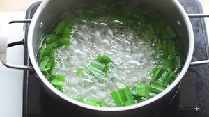 Pandan drink making step, stirring pandan leaf in boiled water by wooden ladle, Asian drink