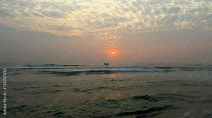 Majestic sunrise over the ocean. Fishing boat at sea during sunrise. Amazing red sunrise. Waves rolling onto the beach during sunrise. My Khe beach. Da Nang, Vietnam.
