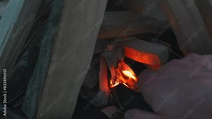 Step-by-step guide on lighting a campfire using kindling and lighter, photographic series showing progression.