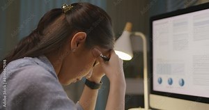 Asia people young woman study hard overnight brownout bored remote learn online read data tired sitting head in hands at home office desk workplace think worry in job tough stress workforce issue.