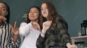 happy group of women friends dancing and singing together enjoying party music at home having fun celebrating weekend reunion gathering vacation. Multicultural Friendship between girls