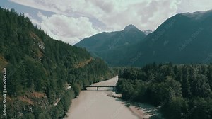 Aerial 4K cinematic footage of the Squamish River, showcasing its winding course through lush, verdant landscapes. Perfect for projects requiring stunning natural backdrops and serene river scenes.