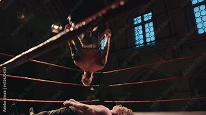 Pro wrestling match - wrestler backflip onto opponent in ring