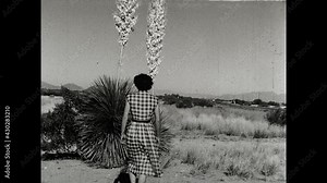 Yucca Blossoms 1950 A woman walks towards a Soaptree Yucca plant in the deserts of the Southwest and opens the flowers.