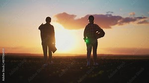 Two women farm workers agronomist manager with tablet in hands discussing harvesting, crop growing making calculations, collecting data on agricultural field at sunset. Agribusiness, work on farmland.
