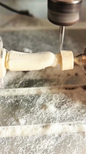 CNC cutter shapes cylinder, fine shavings scatter neatly