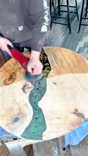 Sanding epoxy river table reveals smooth handcrafted wooden surface