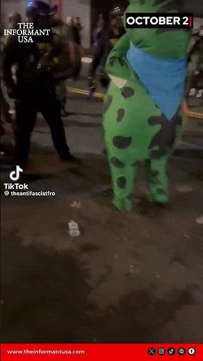 🐸🚨 Portland chaos: DHS officer maces Antifa frog costume during protest.
