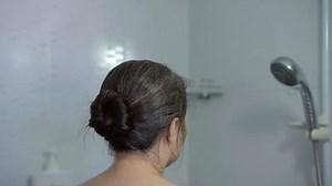 Time lapse close up view of woman showering in shower room