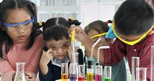 Science teacher teach Asian students in laboratory room, Student drop something into colorful tube, colorful test tube and microscope on table , concept for study in laboratory room.