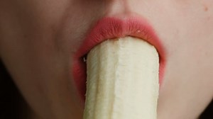 Girl with red lips are eating babana