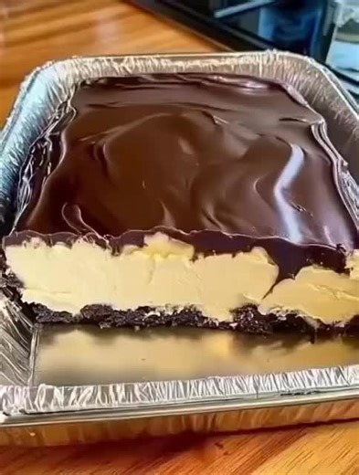 Dish Name: Chocolate Cream Layered Dessert Bars Ingredients: - 200g crushed biscuits - 100g melted butter - 2 cups cream cheese - ½ cup powdered sugar - 1 cup whipped cream - 200g melted chocolate Recipe: 1. Mix crushed biscuits with melted butter and press into a tray. 2. Chill base for 15 minutes until firm. 3. Beat cream cheese and sugar until smooth. 4. Fold in whipped cream to create a light filling. 5. Spread mixture over the base evenly. 6. Pour melted chocolate on top and smooth it out. 
