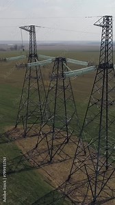 Power line, industrial view from a height on the line of electric transmissions in field, steel tower with wires and communication of electric power supply, vertical video.